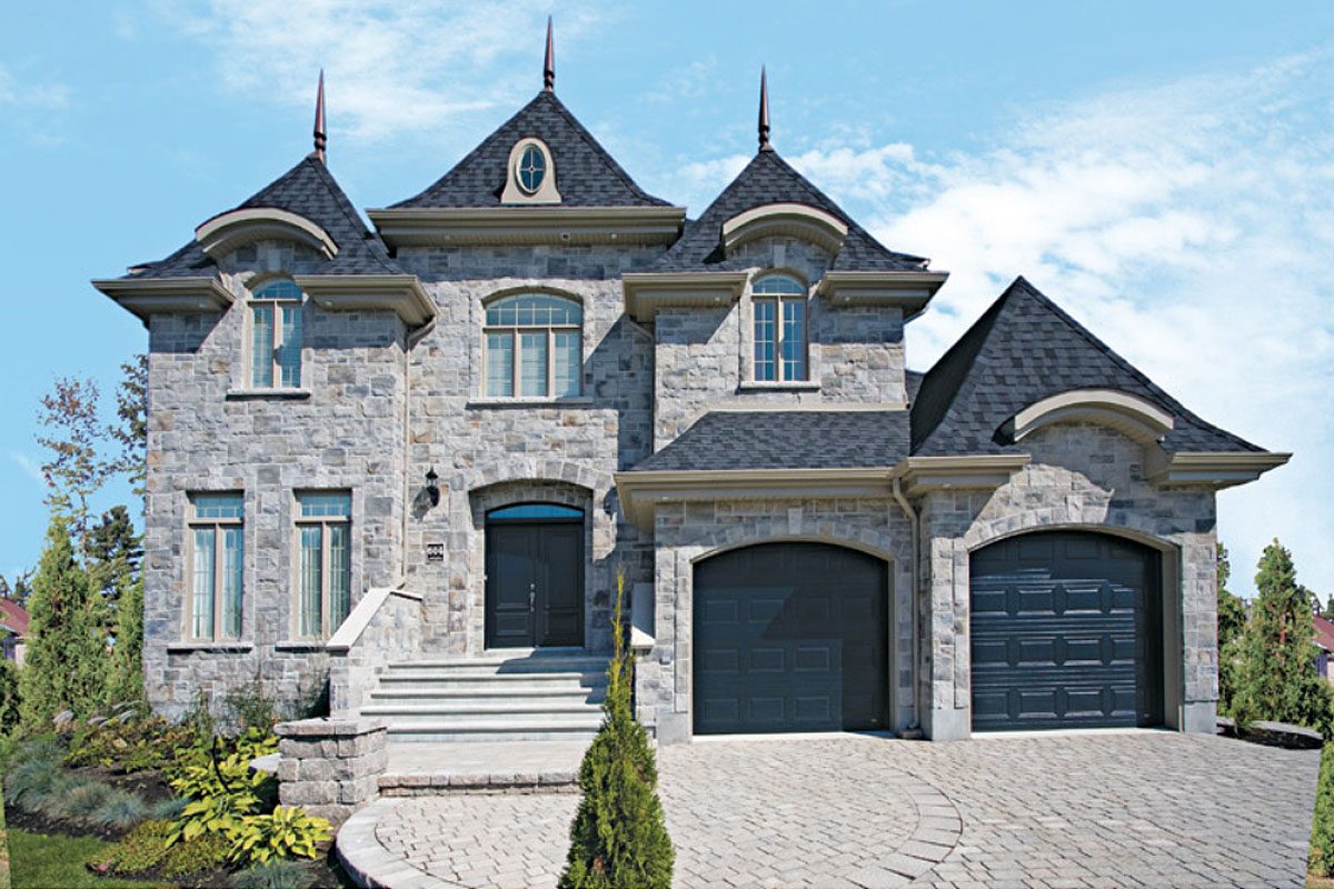 L'Aristocrate : maison classique en pierre pâle avec tourelles, toits en pente et garage double